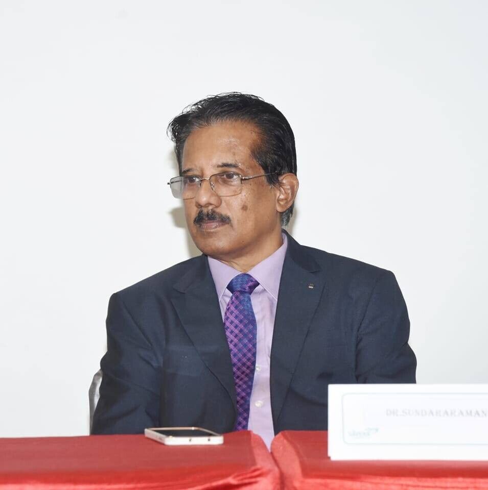 Dr. Sundararaman Chintamani seated at dais with name plate at NIPM Madras Chapter event