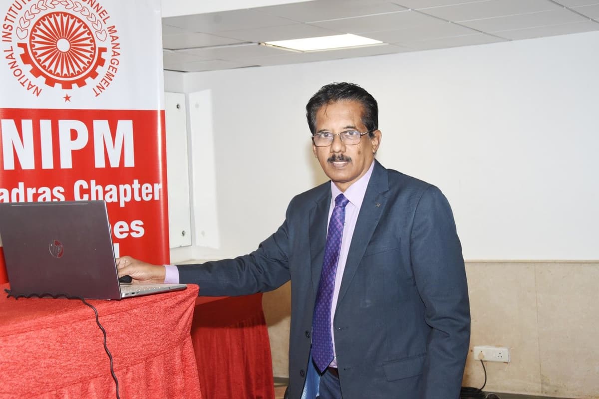 Dr. Sundararaman Chintamani next to NIPM banner with laptop preparing for Business Storytelling session