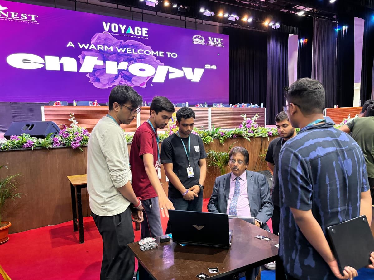 Dr. Sundararaman reviewing team laptop with Entropy banner at VIT Chennai hackathon