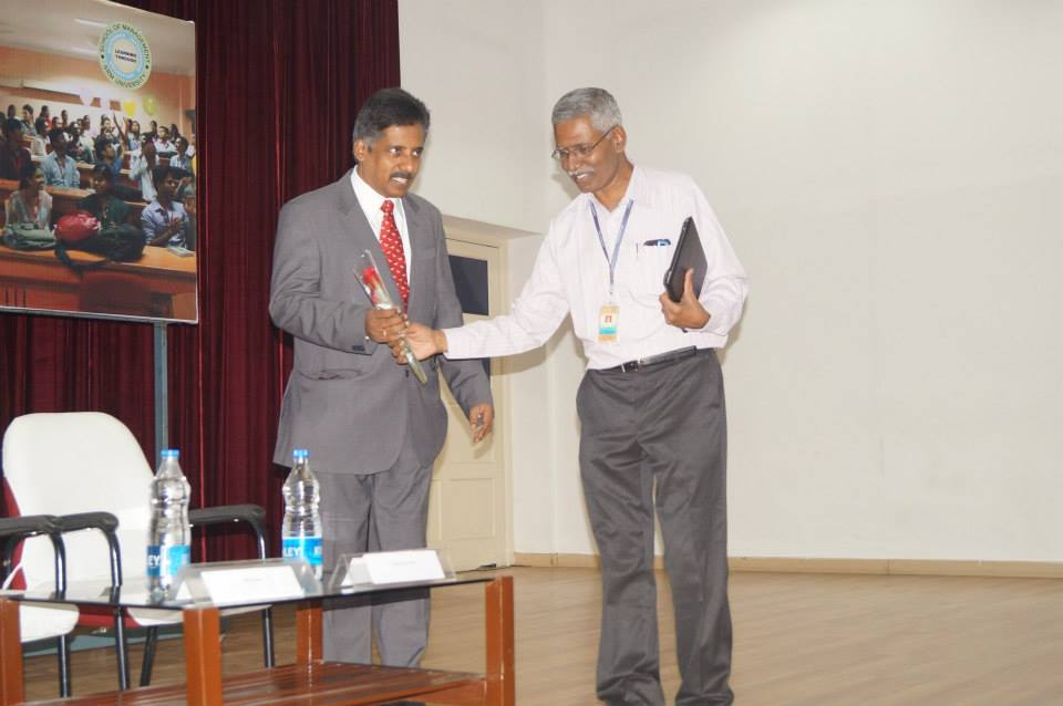 Dr. Sundararaman receiving bouquet from the Dean at SRM University