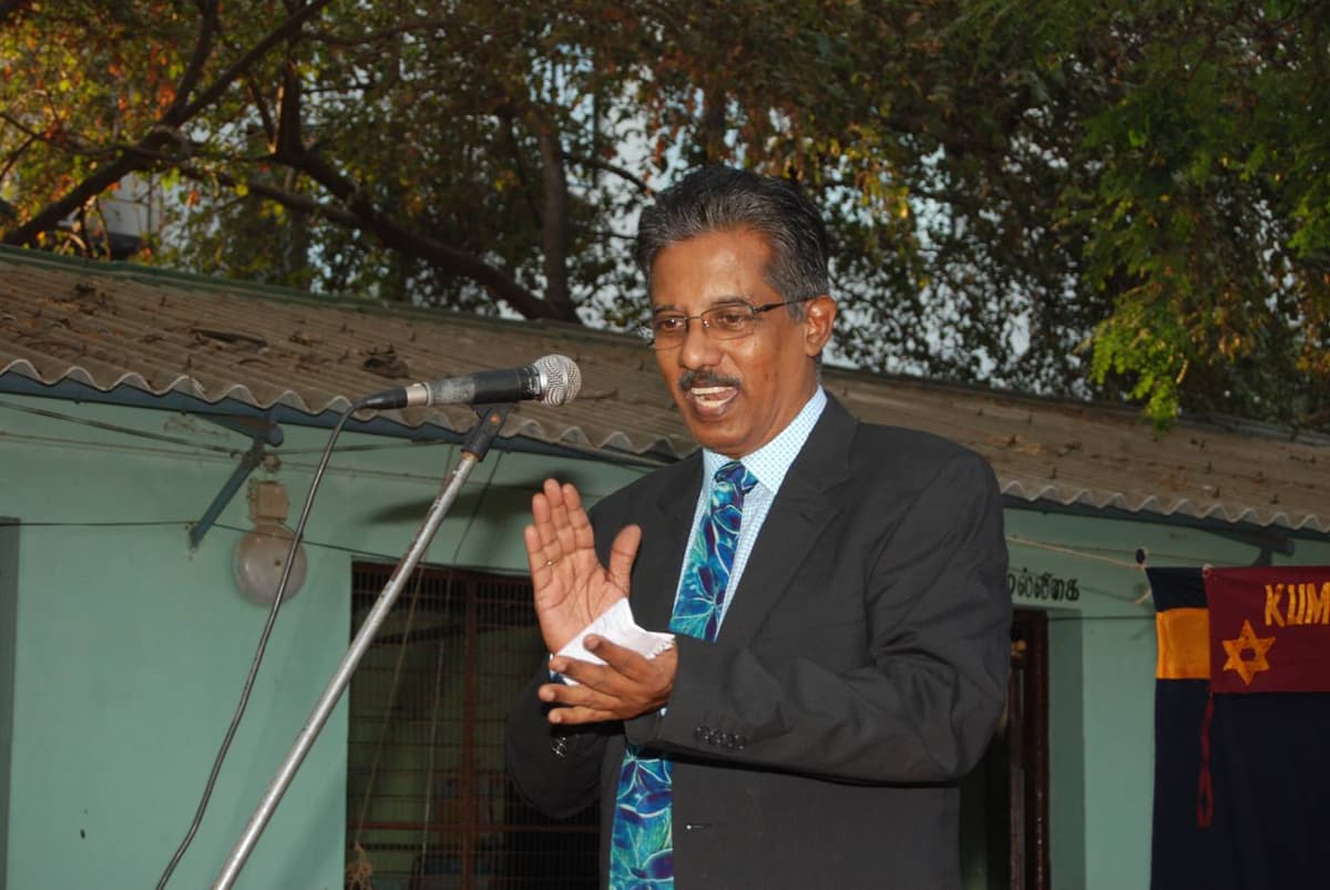 Dr. Sundararaman speaking at microphone at 61st Annual Day of Kumararajah Muthiah Middle School