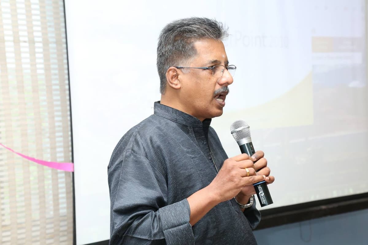 Dr. Sundararaman presenting with projector screen at Selvi Kandaraj Trust event