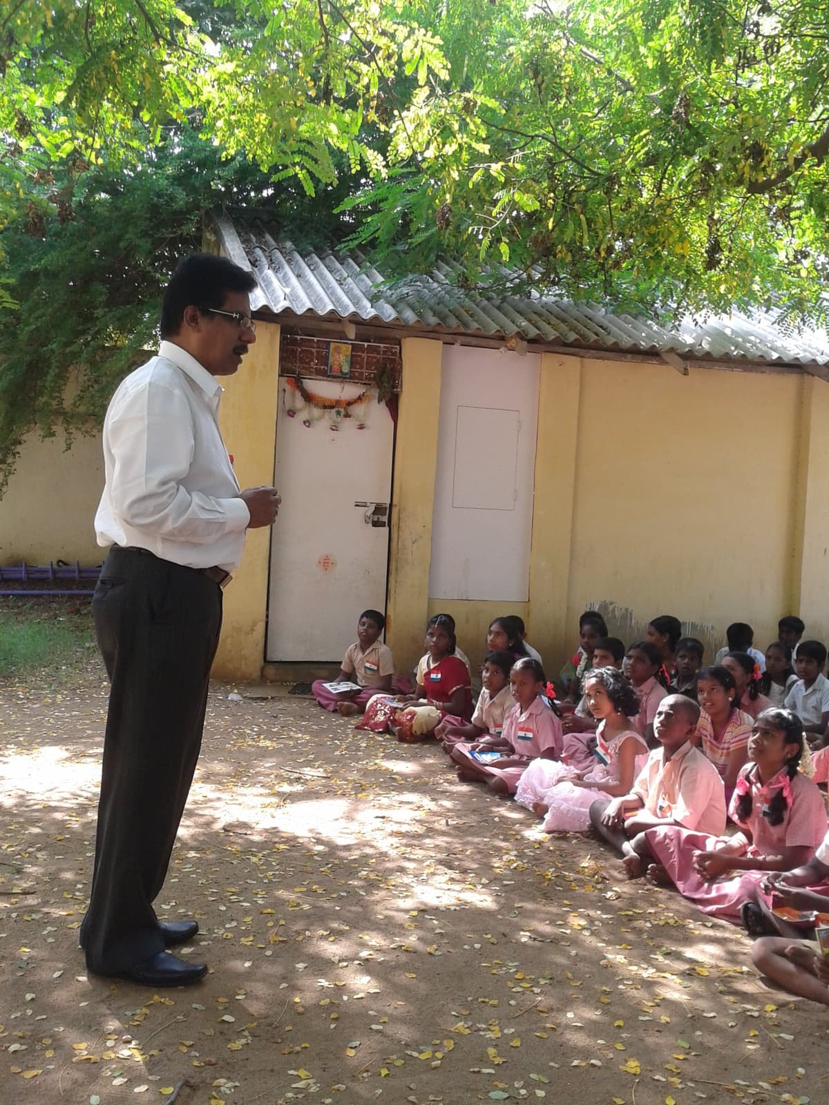Dr. Sundararaman addressing students seated in school courtyard on Independence Day