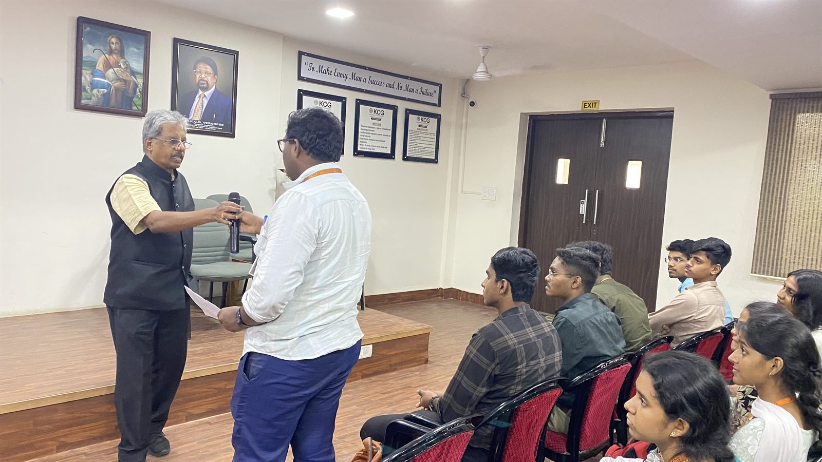 Dr. Sundararaman Chintamani handing the microphone to a student during the Systems Thinking session at KCG College of Technology