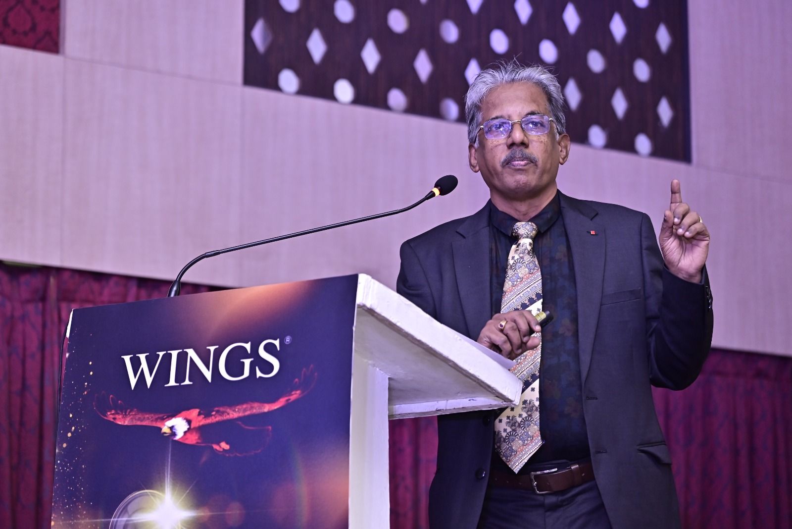 Dr. Sundararaman speaking at the Wings podium during the keynote